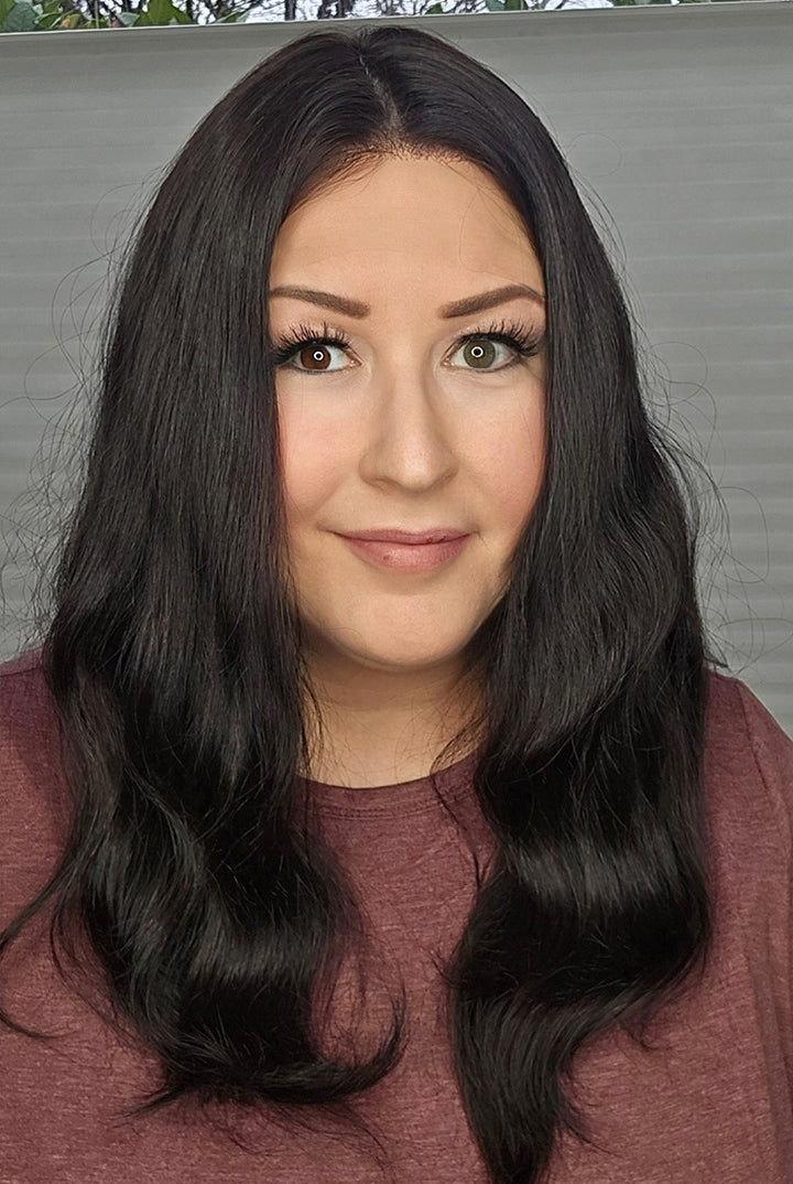 Woman with long black hair wearing a maroon top against a neutral background