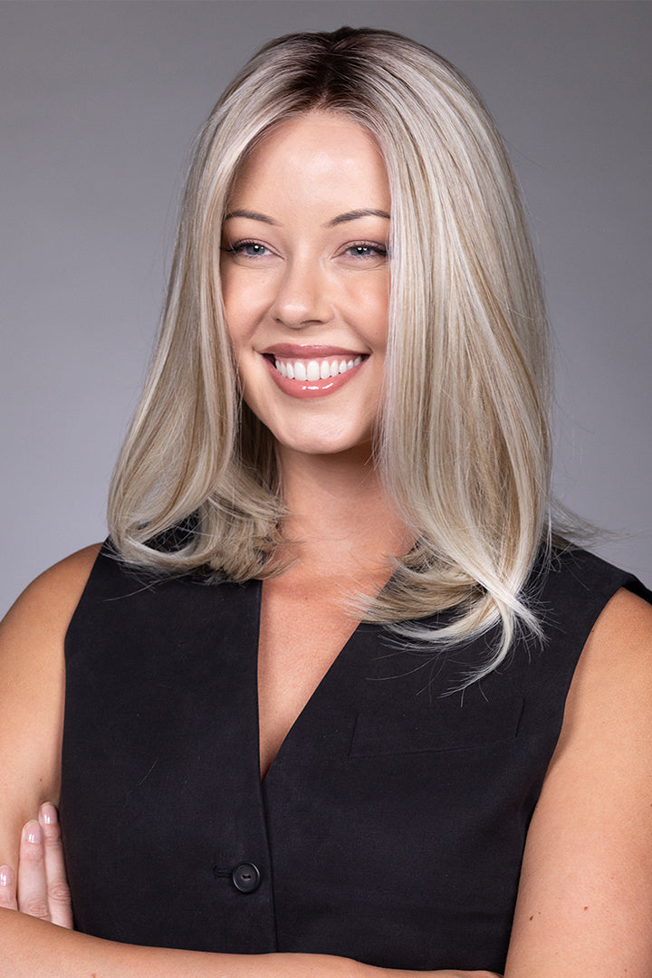Adriana by Belle Tress layered blonde bob wig with a natural lace front and monofilament top on a smiling model.