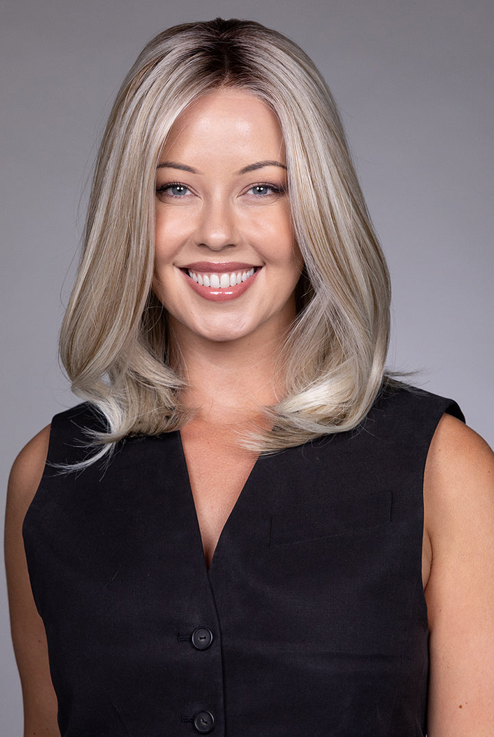 Adriana by Belle Tress layered blonde bob wig with lace front and monofilament top on a smiling model.