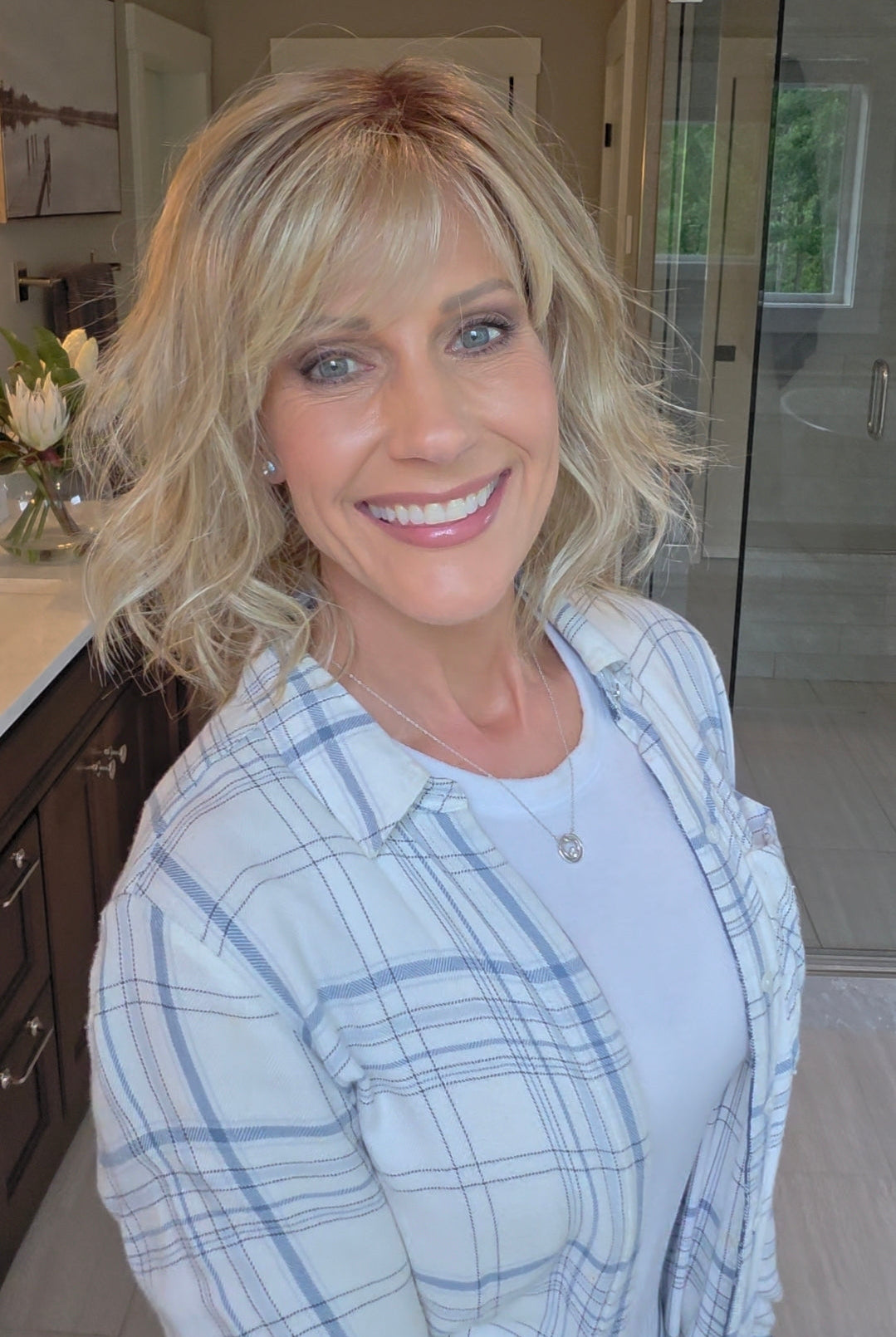 Woman wearing short wavy bob with bangs (Terra by Amore in Rose Gold R).