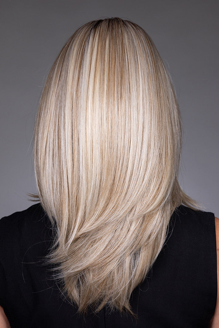 Back view of Bailey by Belle Tress, a mid-length layered blonde synthetic wig with a sleek, polished finish.