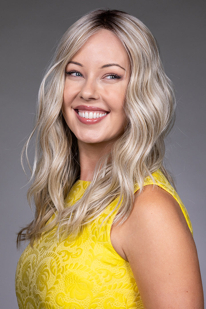 Bella by Belle Tress long wavy blonde synthetic wig with a natural lace front and monofilament top.