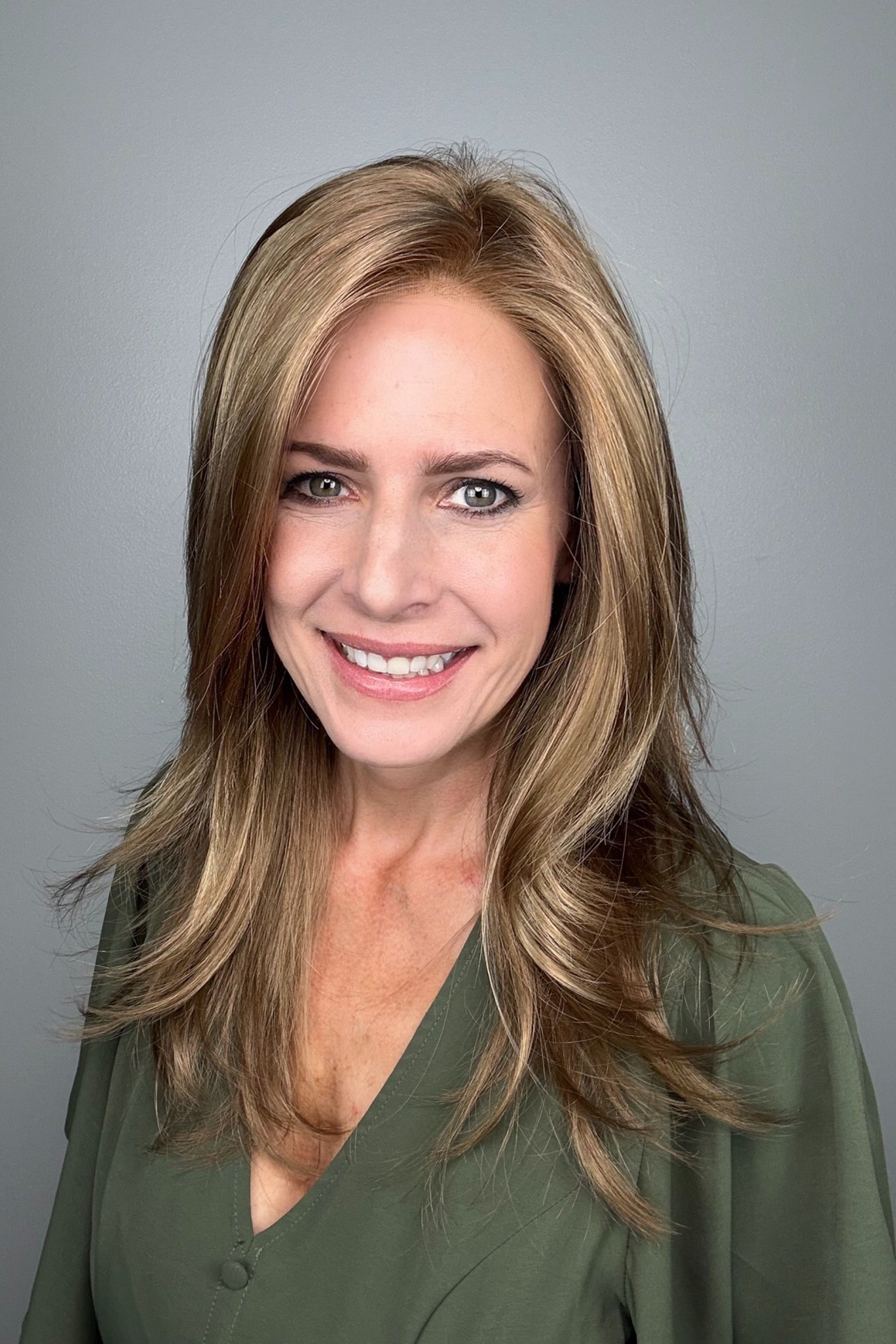 Woman wearing long layered bronde wig (Belinda Hand-Tied by Envy in Mocha Frost).