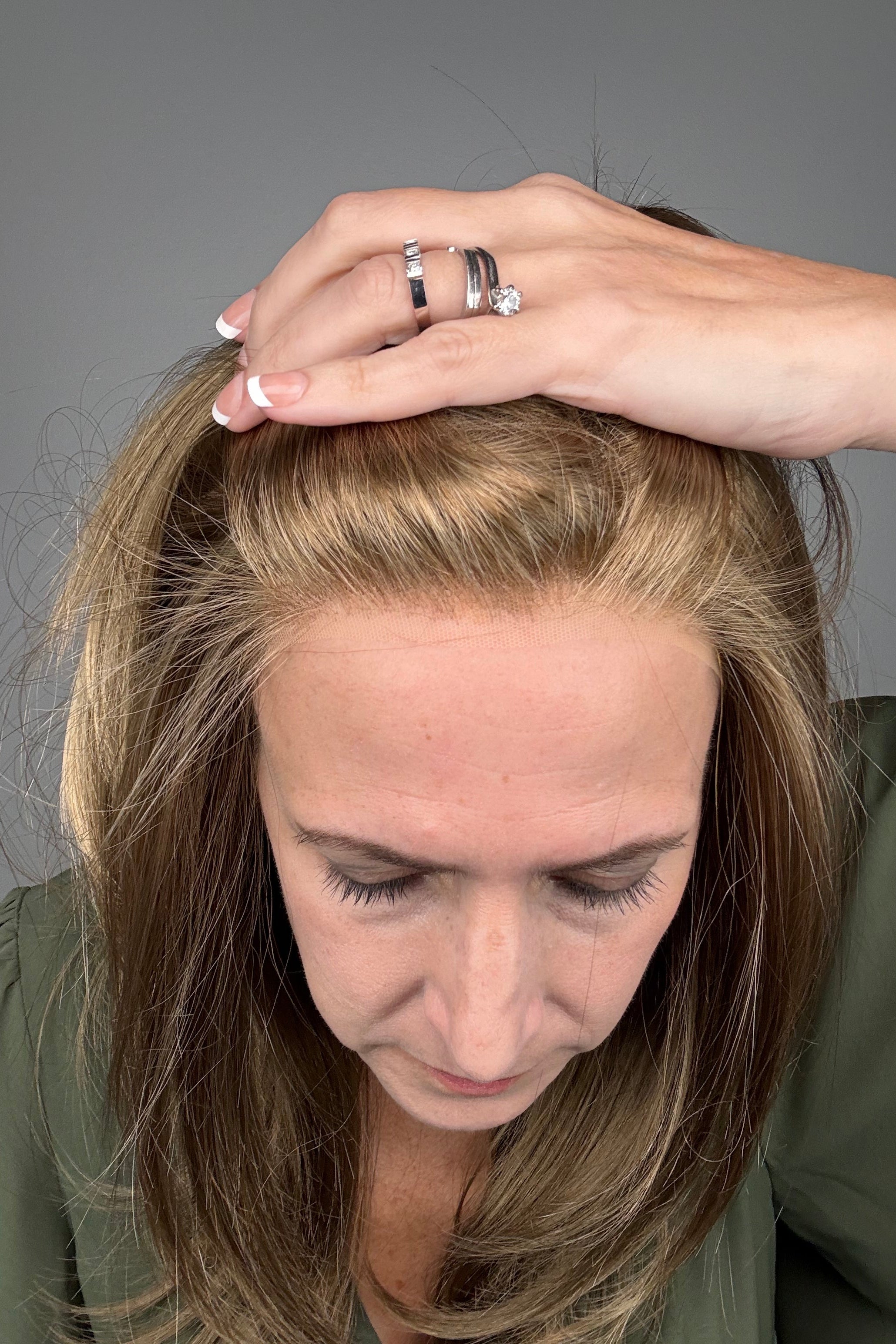 Woman wearing long layered bronde wig (Belinda Hand-Tied by Envy in Mocha Frost).