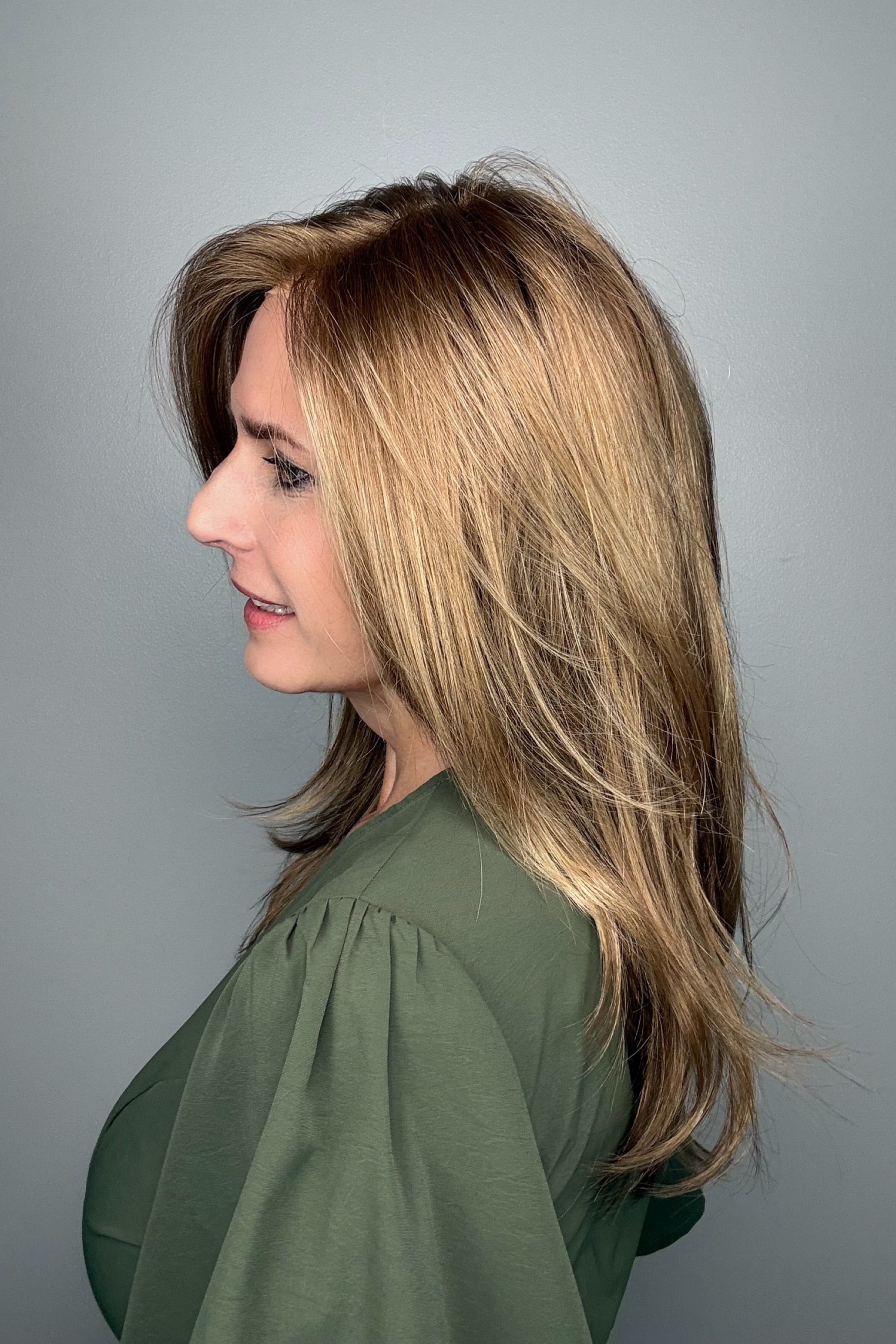 Woman wearing long layered bronde wig (Belinda Hand-Tied by Envy in Mocha Frost).