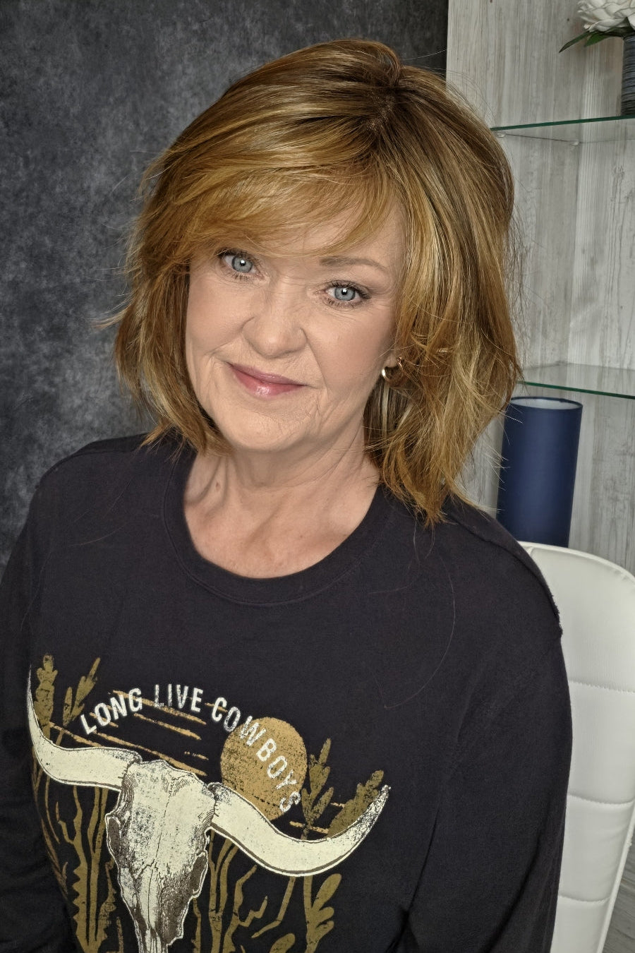 Woman wearing layered bob wig with bangs (Emilia by Belle Tress in Butter Pecan R).