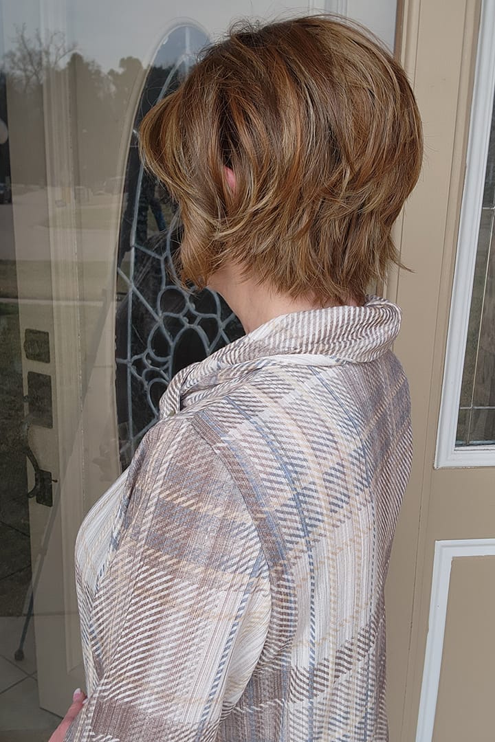 Woman with reddish-brown chin-length bob wig (Marni by Belle Tress in Butter Pecan) back