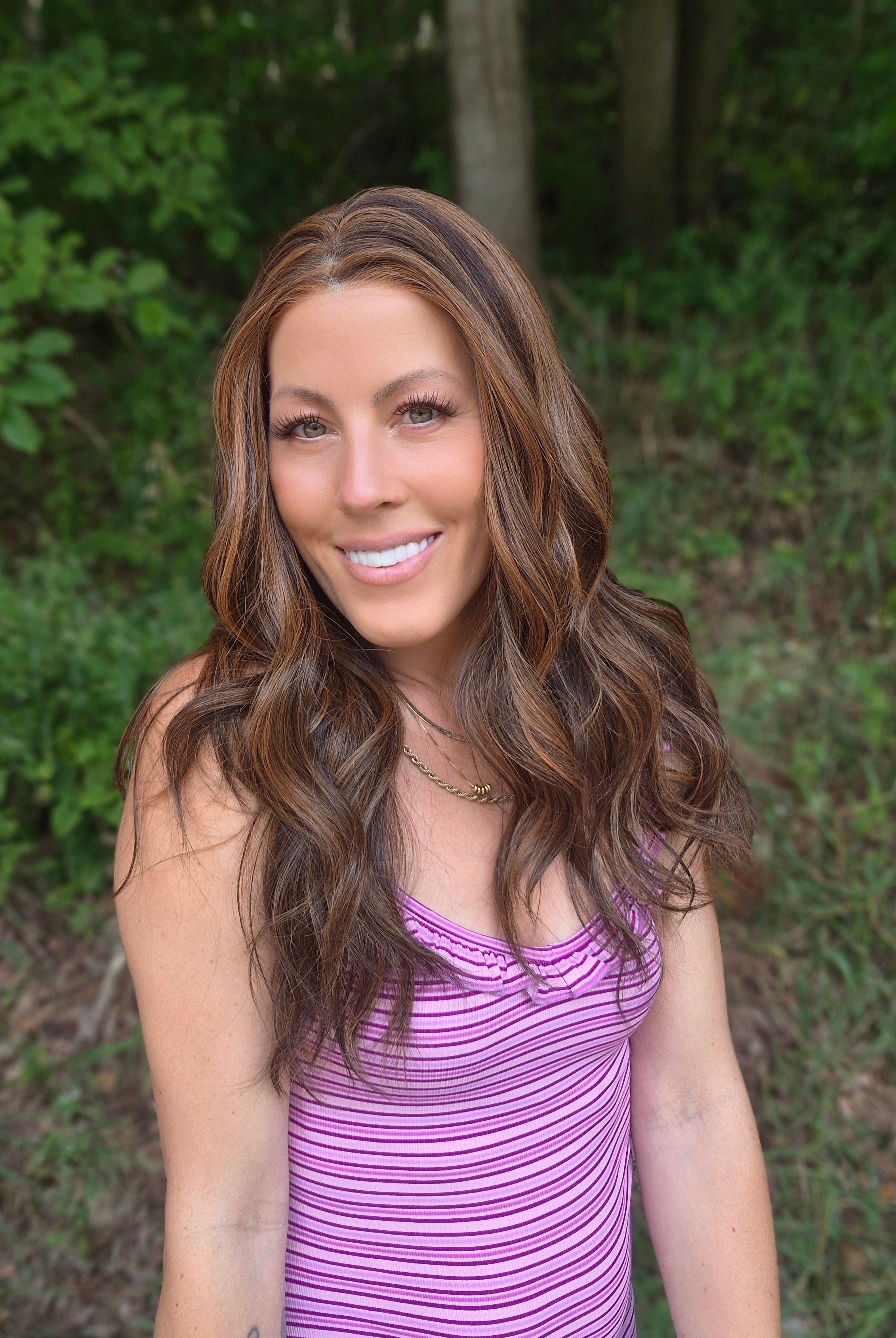 Woman wearing extra long wavy brunette wig (Bradley by PUSH Hair in color Sunlit Brunette).