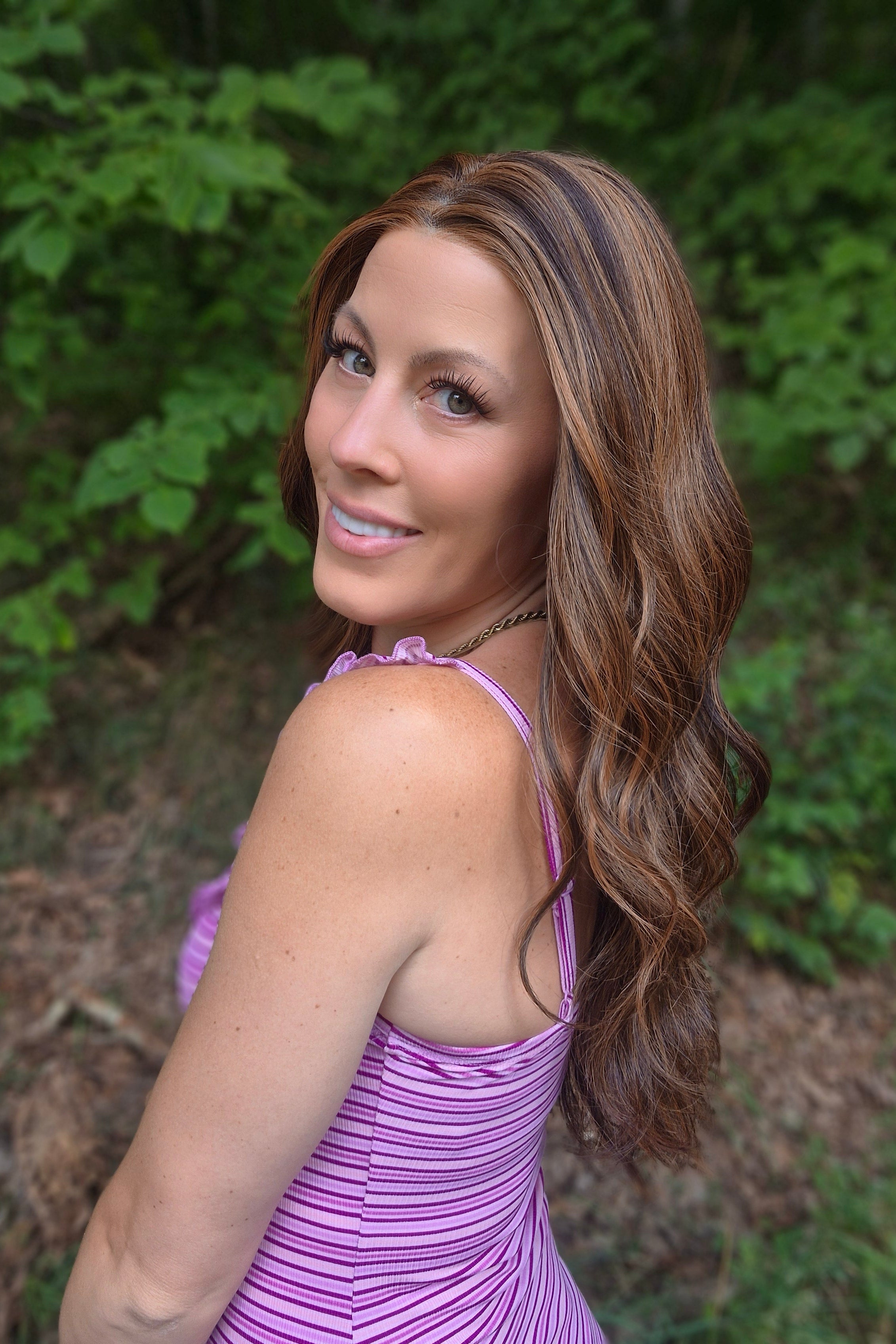 Woman wearing extra long wavy brunette wig (Bradley by PUSH Hair in color Sunlit Brunette).