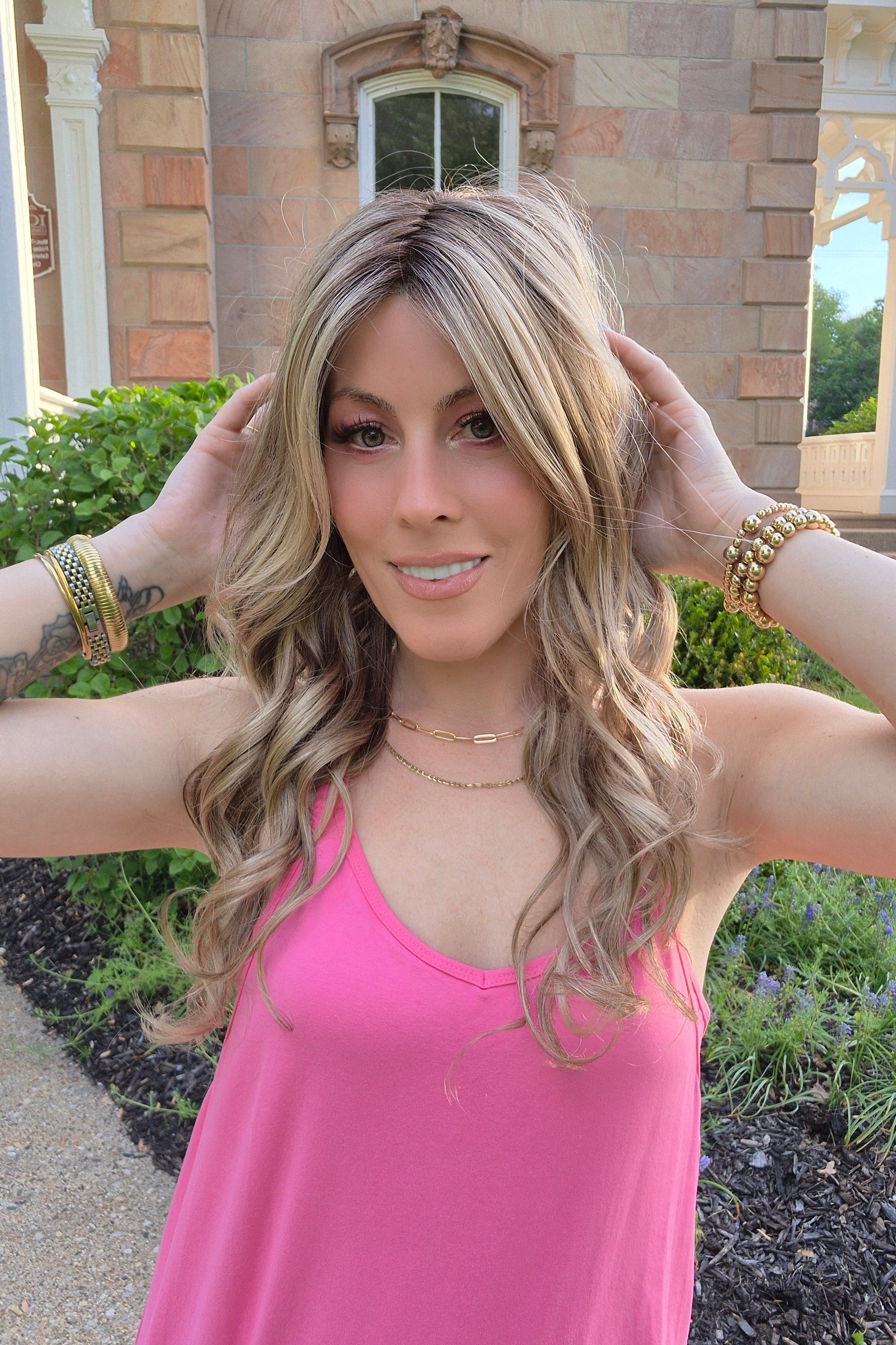 Woman wearing long layered wig with beachy waves (Brianna Hand-Tied in Prosecco).