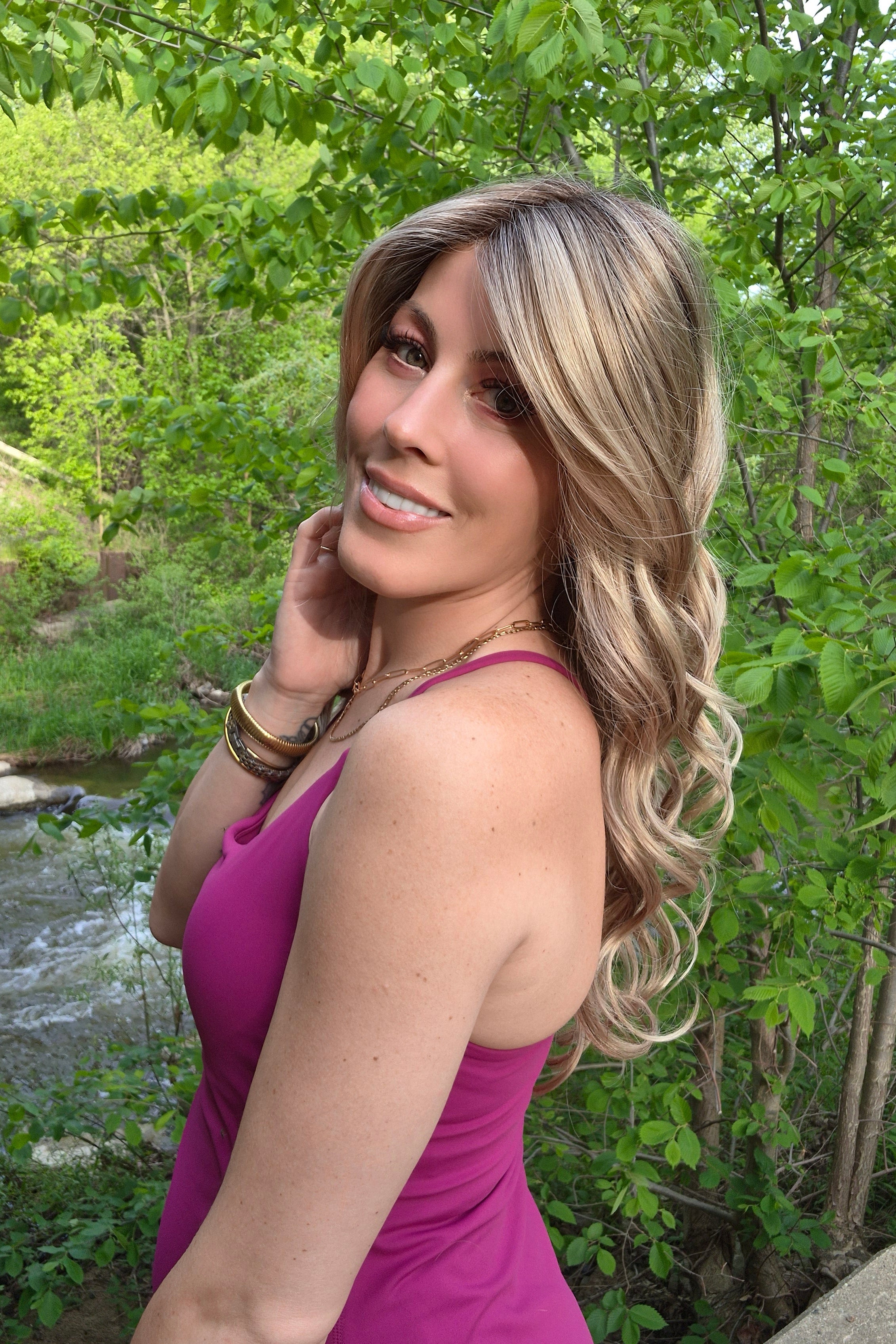 Woman wearing long layered wig with beachy waves (Brianna Hand-Tied in Prosecco).