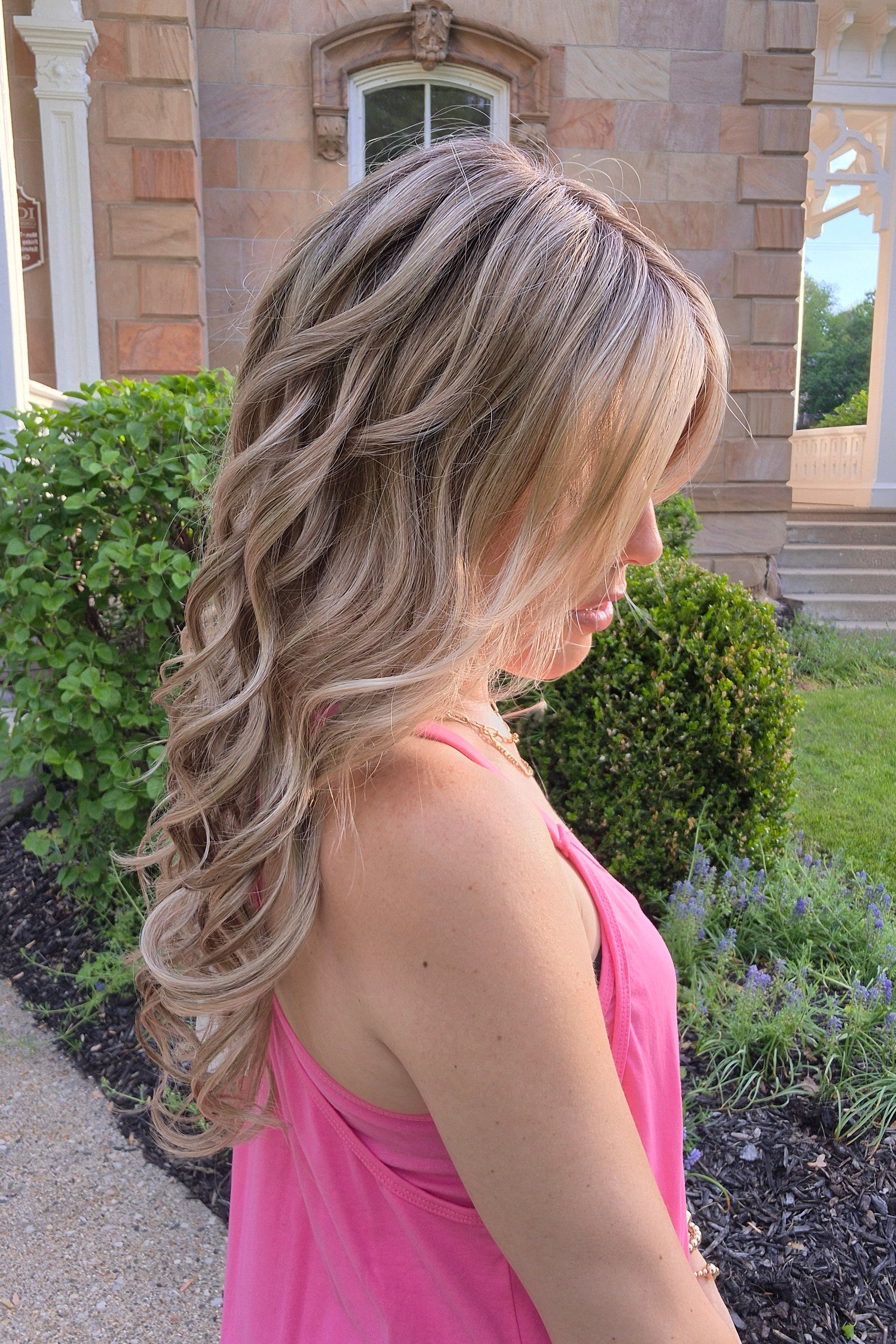 Woman wearing long layered wig with beachy waves (Brianna Hand-Tied in Prosecco).