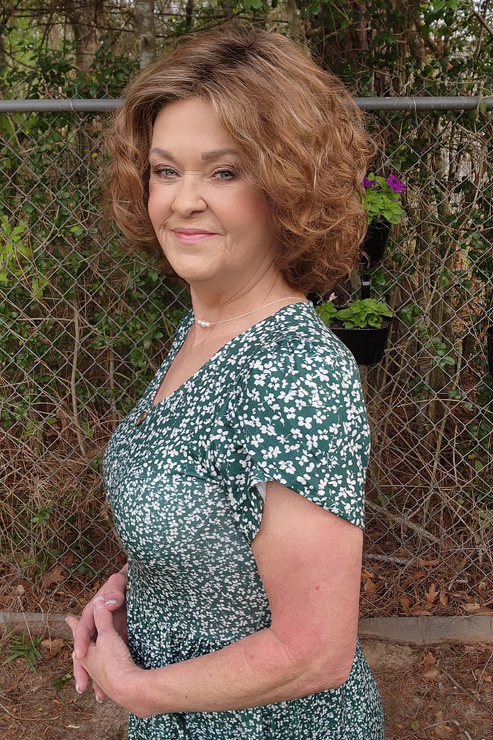 Woman wearing curly bob wig (Loop by Ellen Wille in color Tobacco R) side