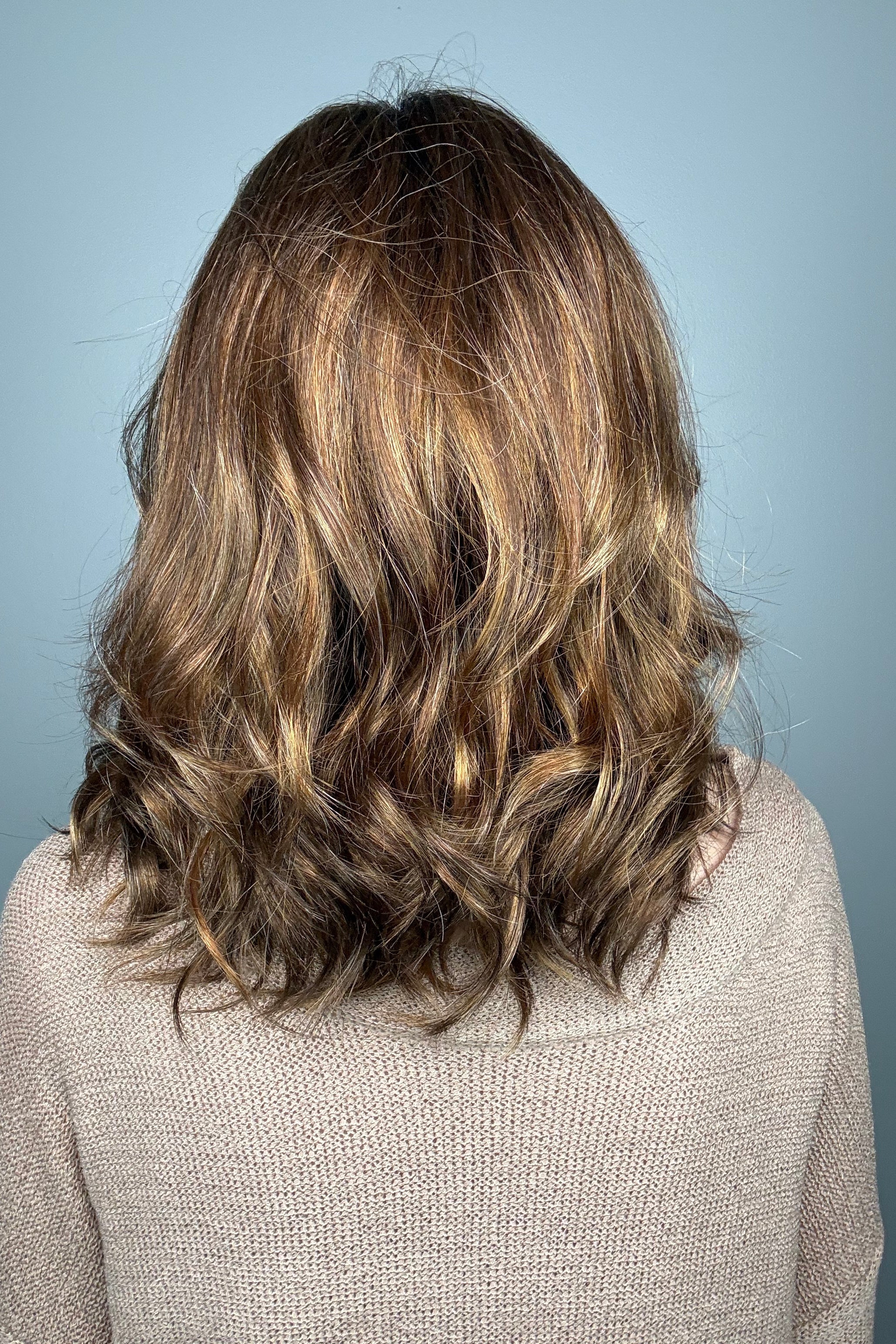 Woman with shoulder-length brown wavy bob wig (Energy by Gabor in Hazelnut)