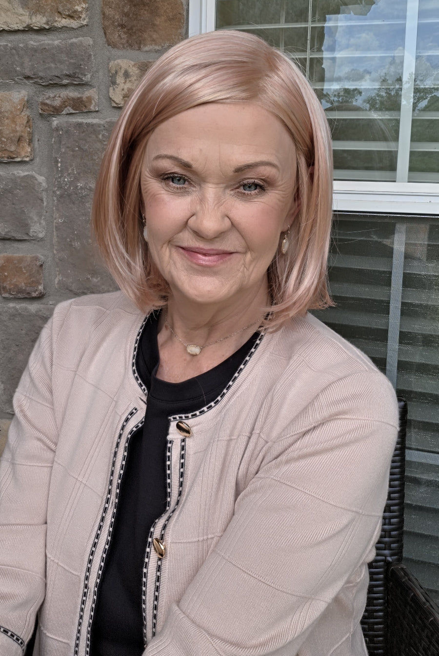 Woman wearing pink bob wig (Jamison by Estetica in color Smoky Rose).