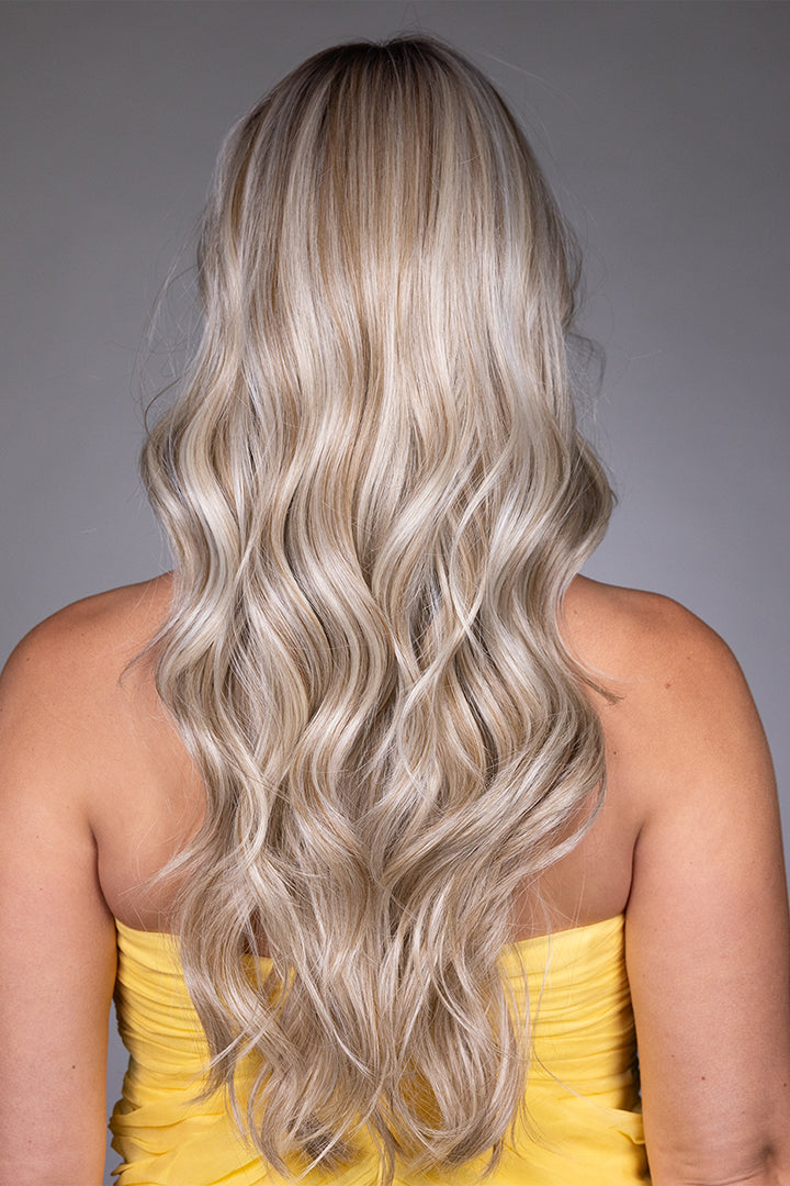 Gisele by Belle Tress long blonde synthetic wig with cascading waves and a natural monofilament top.