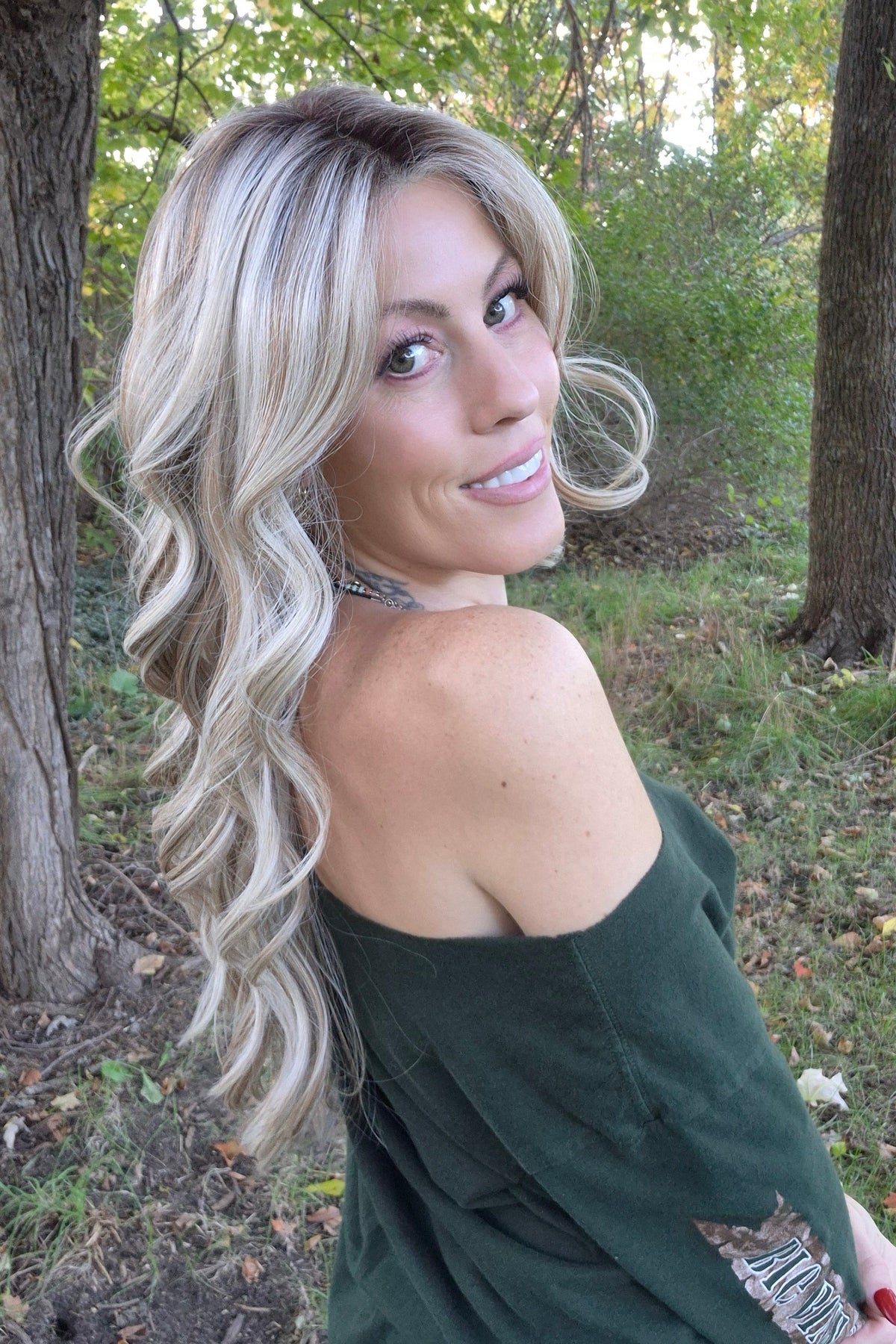 A woman with long blonde wavy wig (Gisele by Belle Tress in color Butterbeer R).