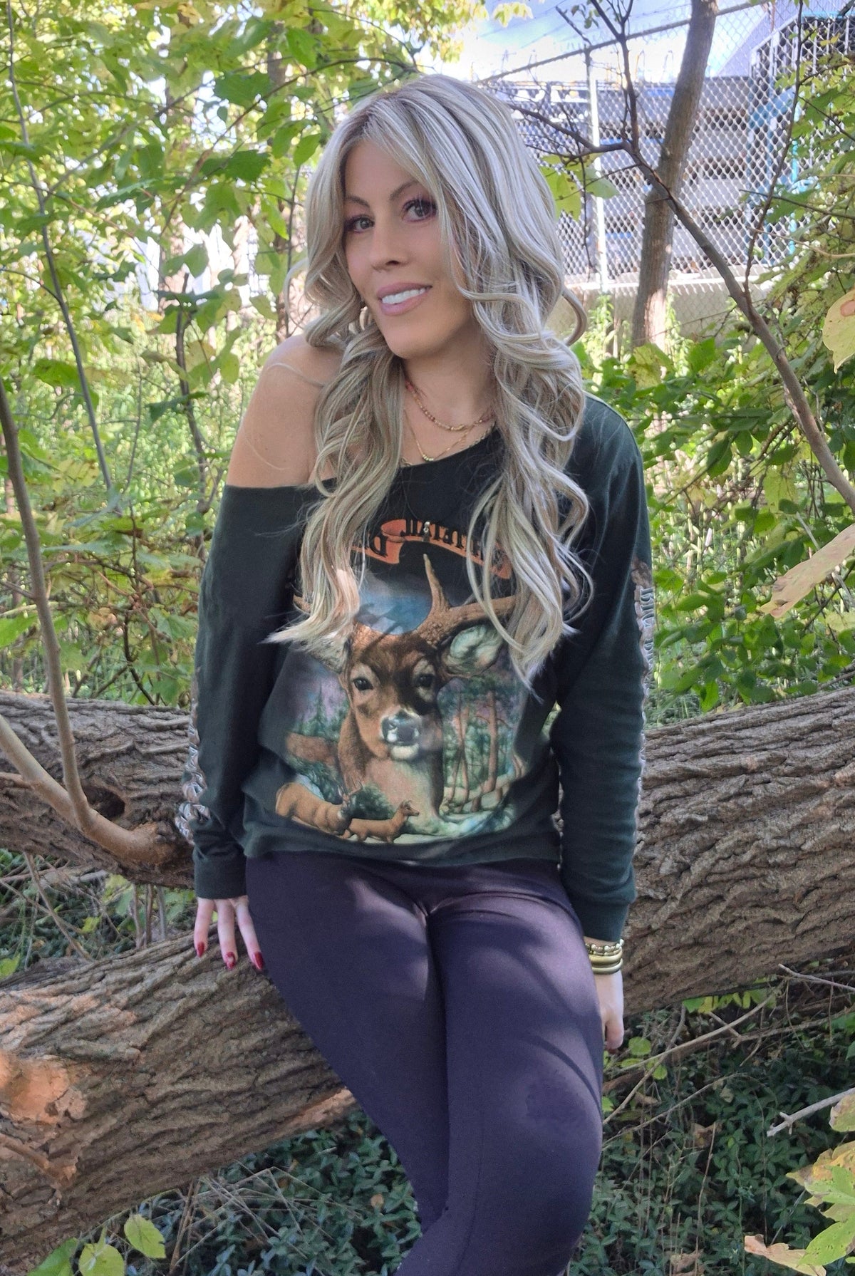 A woman with long blonde wavy wig (Gisele by Belle Tress in color Butterbeer R).