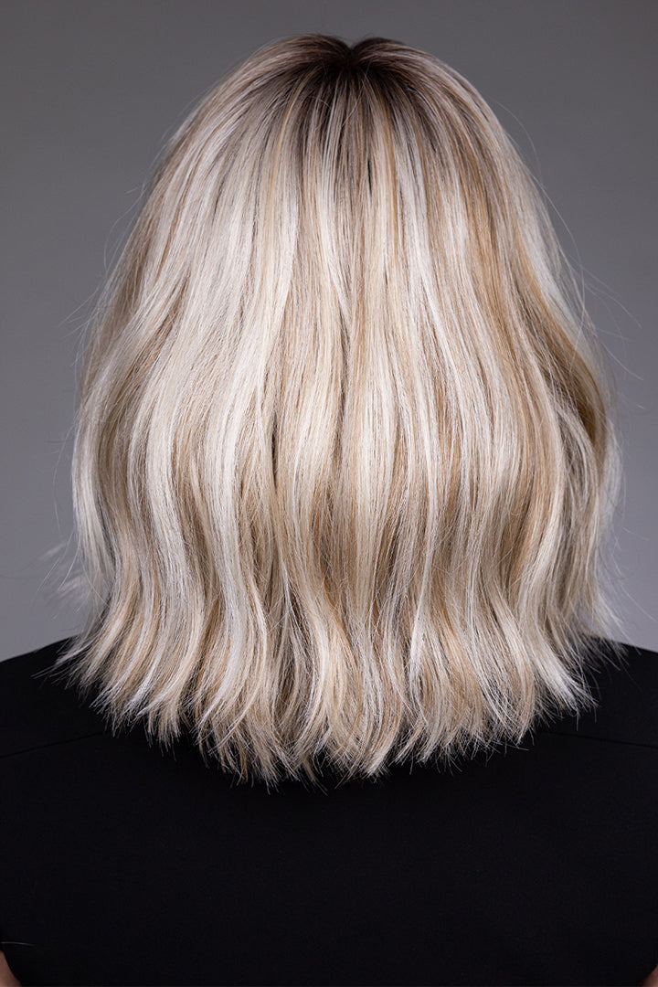 Back view of Indie by Belle Tress, a shoulder-grazing blonde synthetic bob wig with textured, wavy layers.