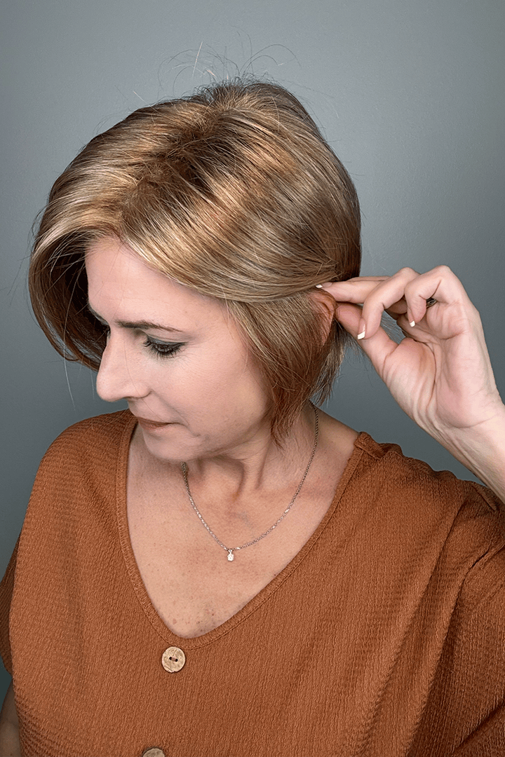 Woman wearing short angled bob cut blonde wig (Jon Renau's Idalia in 12FS8) pulled back