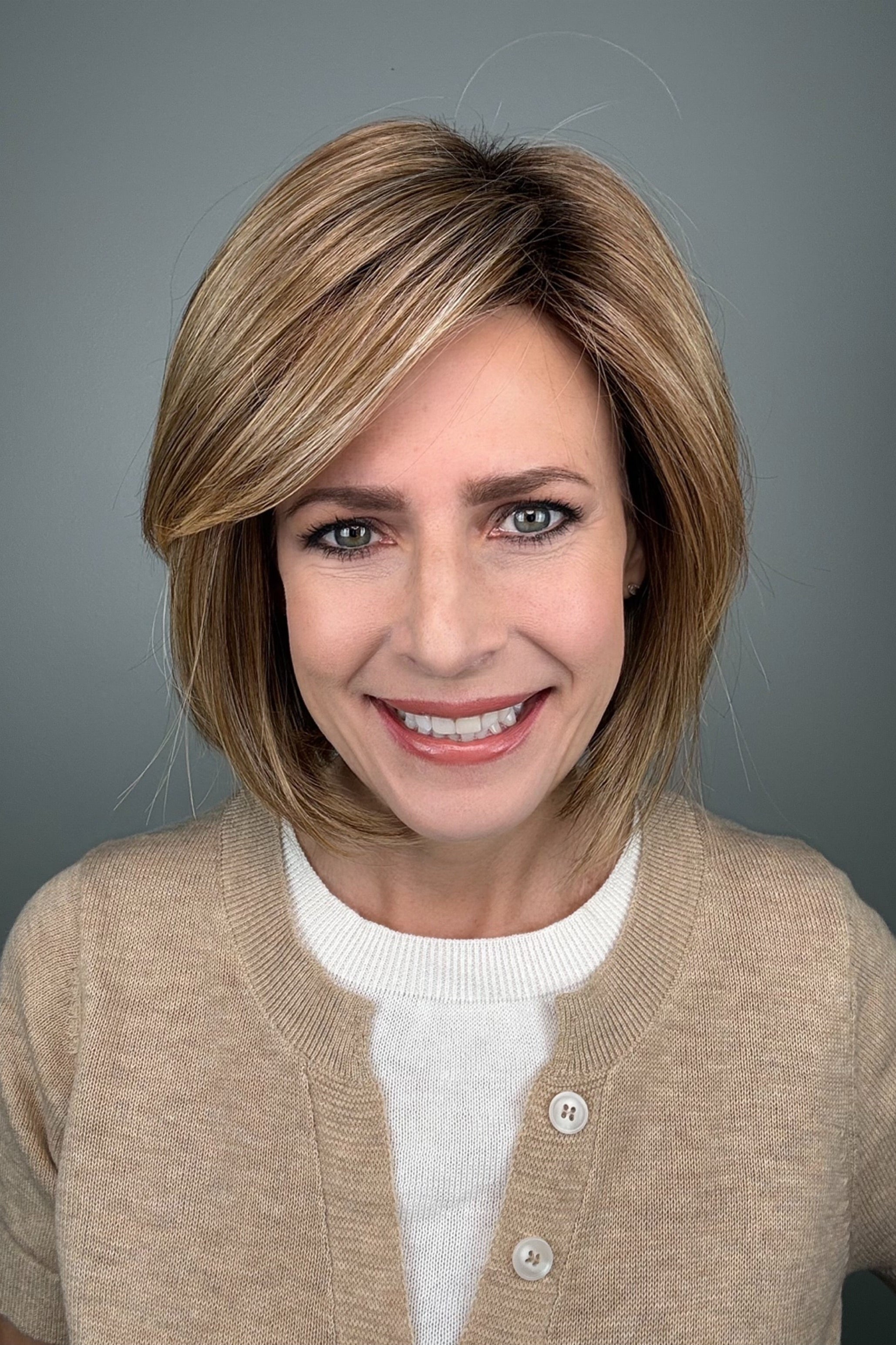 Woman wearing blonde bob with bangs (Meadow by Henry Margu in 12/26GR).