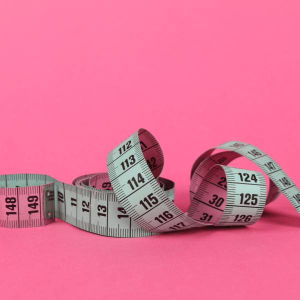 Measuring tape on a pink background