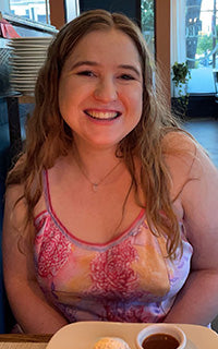 Woman sitting at a table with a tray of food