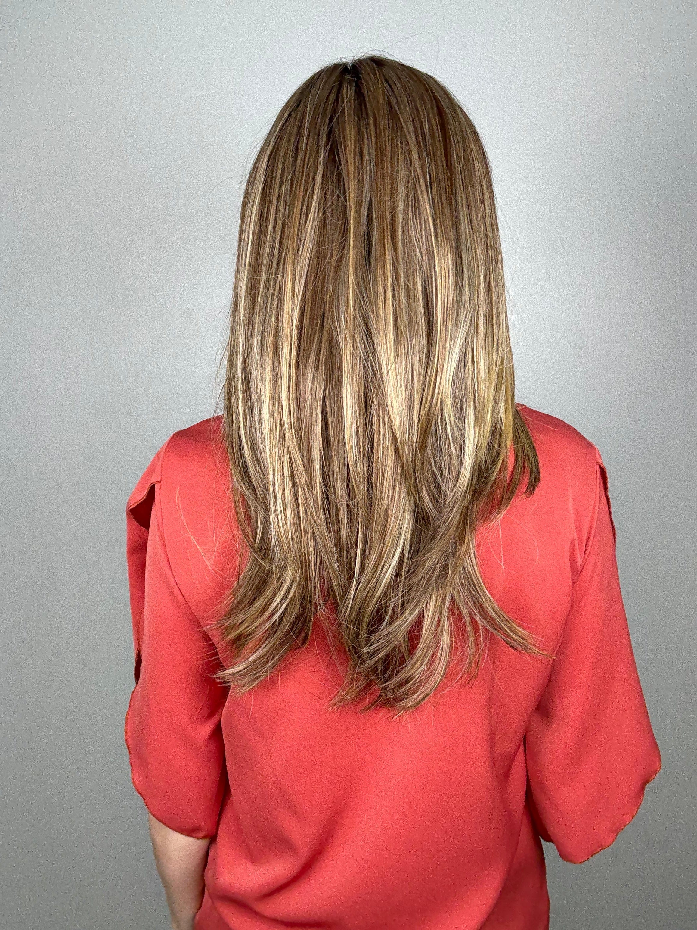 Woman wearing long layered wig (Mirror Moment by Gabor in Honey Pecan) back