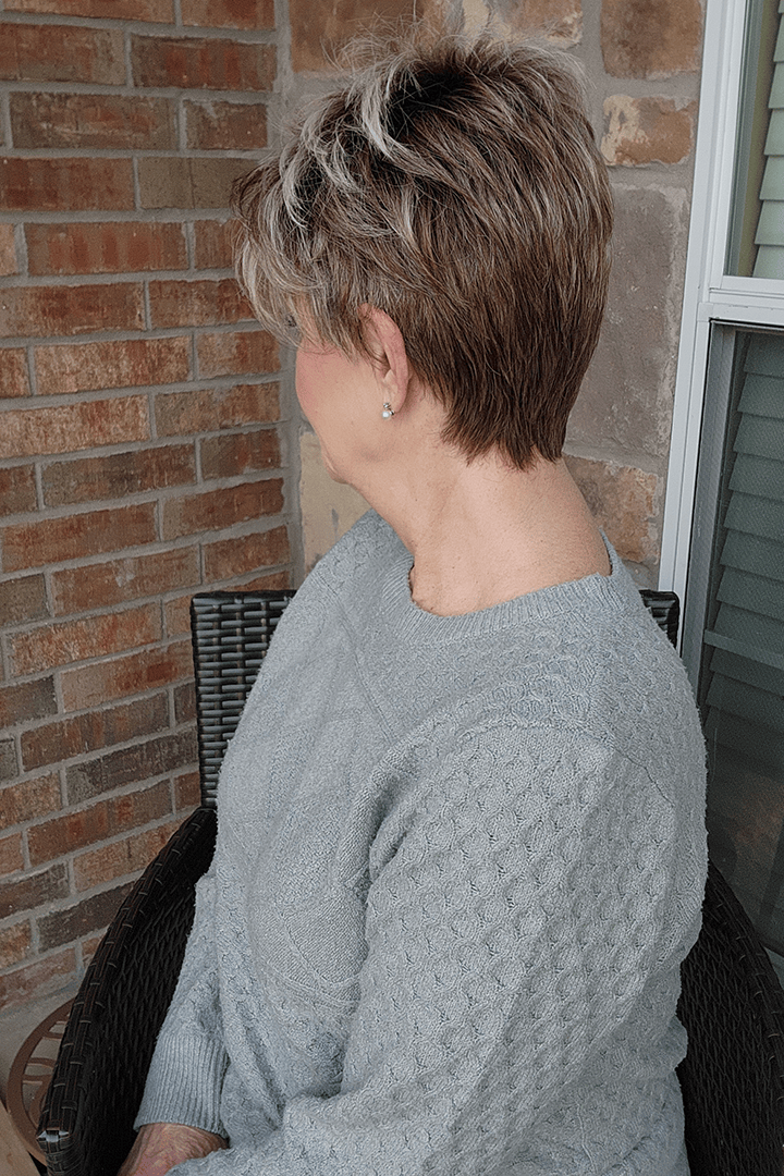 Woman wearing short rooted gray pixie wig (Noriko's Rin in color Snowy Umber) back