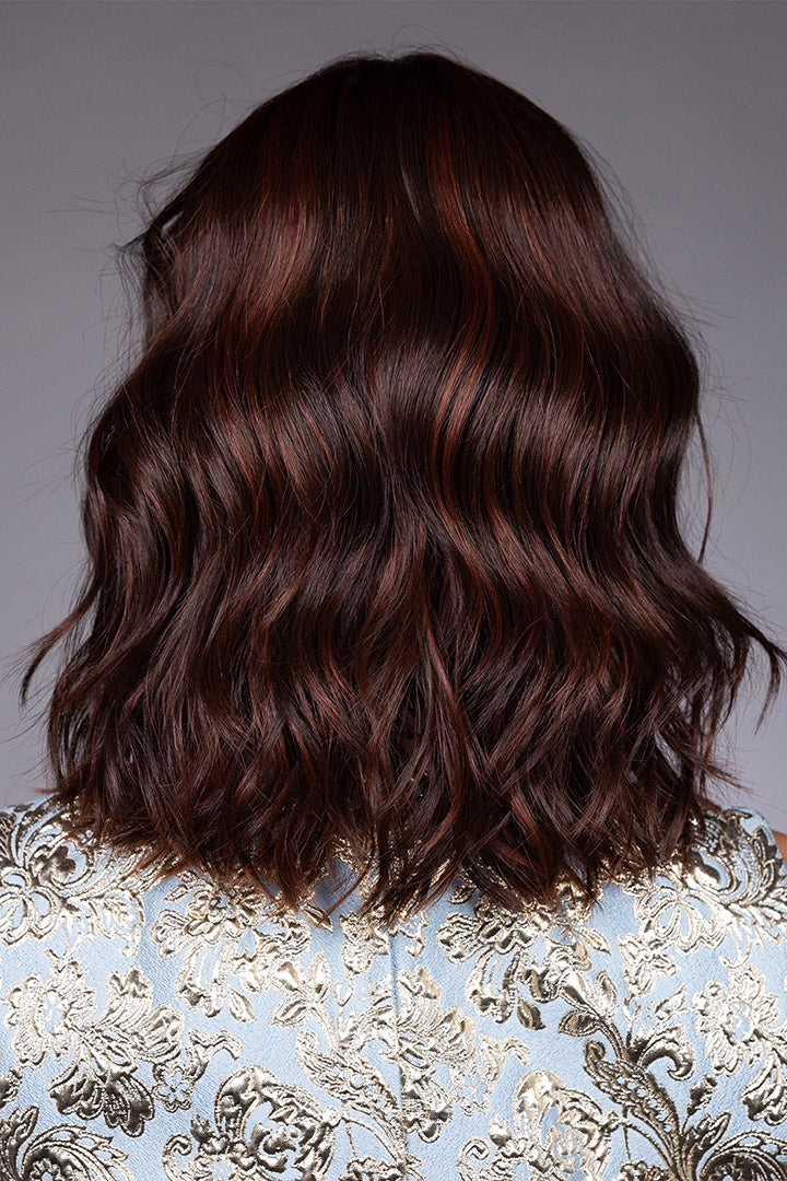 Back view of a shoulder-length, wavy auburn bob wig with textured layers and heat-friendly synthetic fiber.