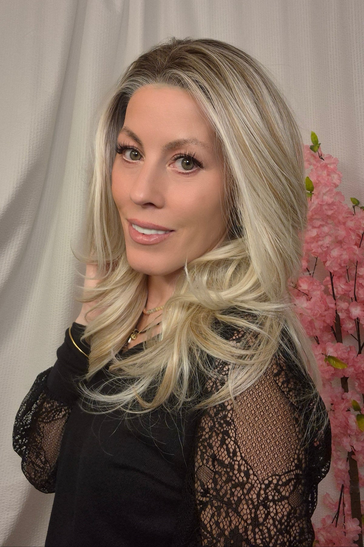 A woman with long, wavy blonde wig (Olivia by PUSH Hair in color Champagne Blonde R).
