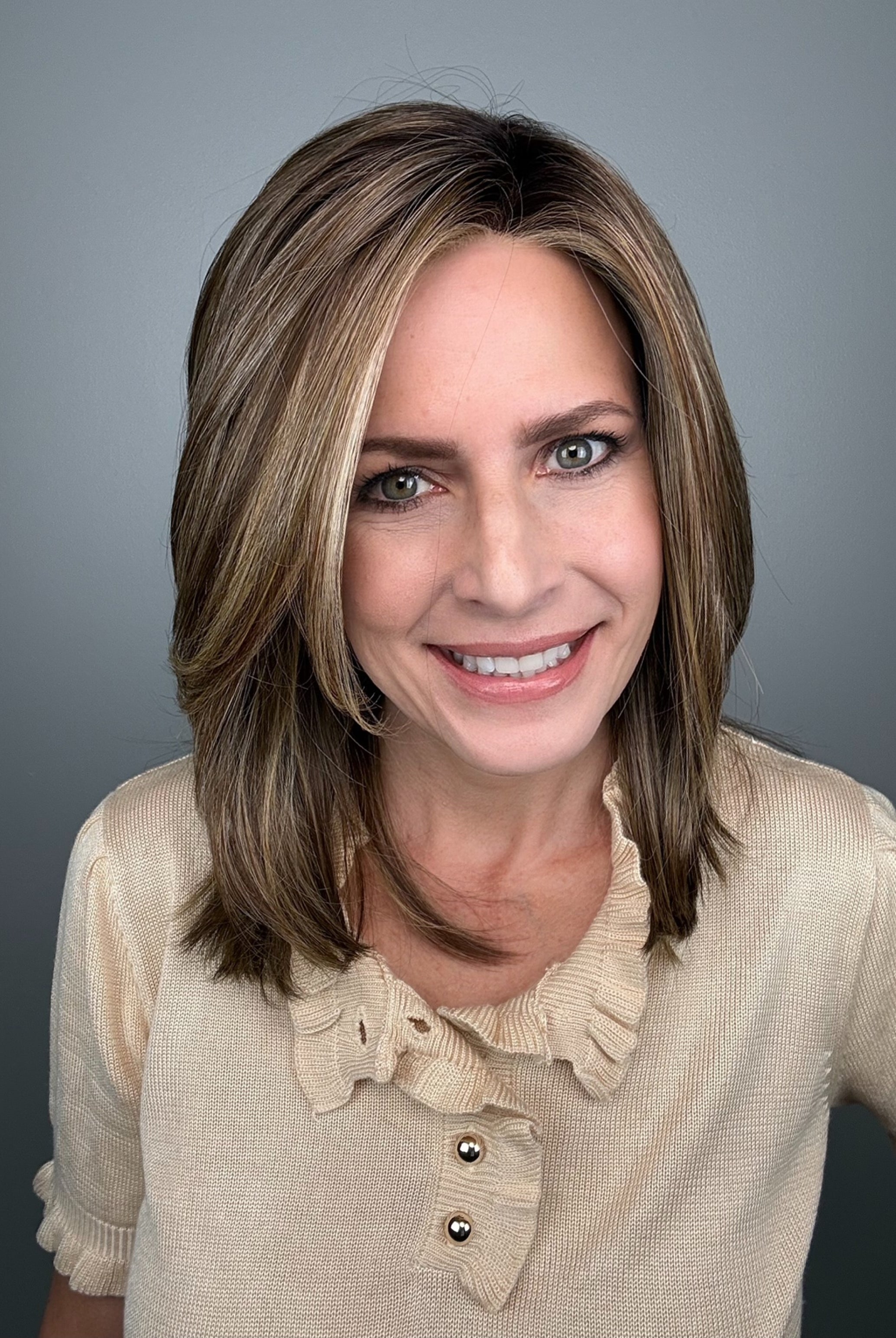 Woman with shoulder-length brown layered wig with side bangs (Own the Room by Gabor in Shaded Iced Cafe Latte)