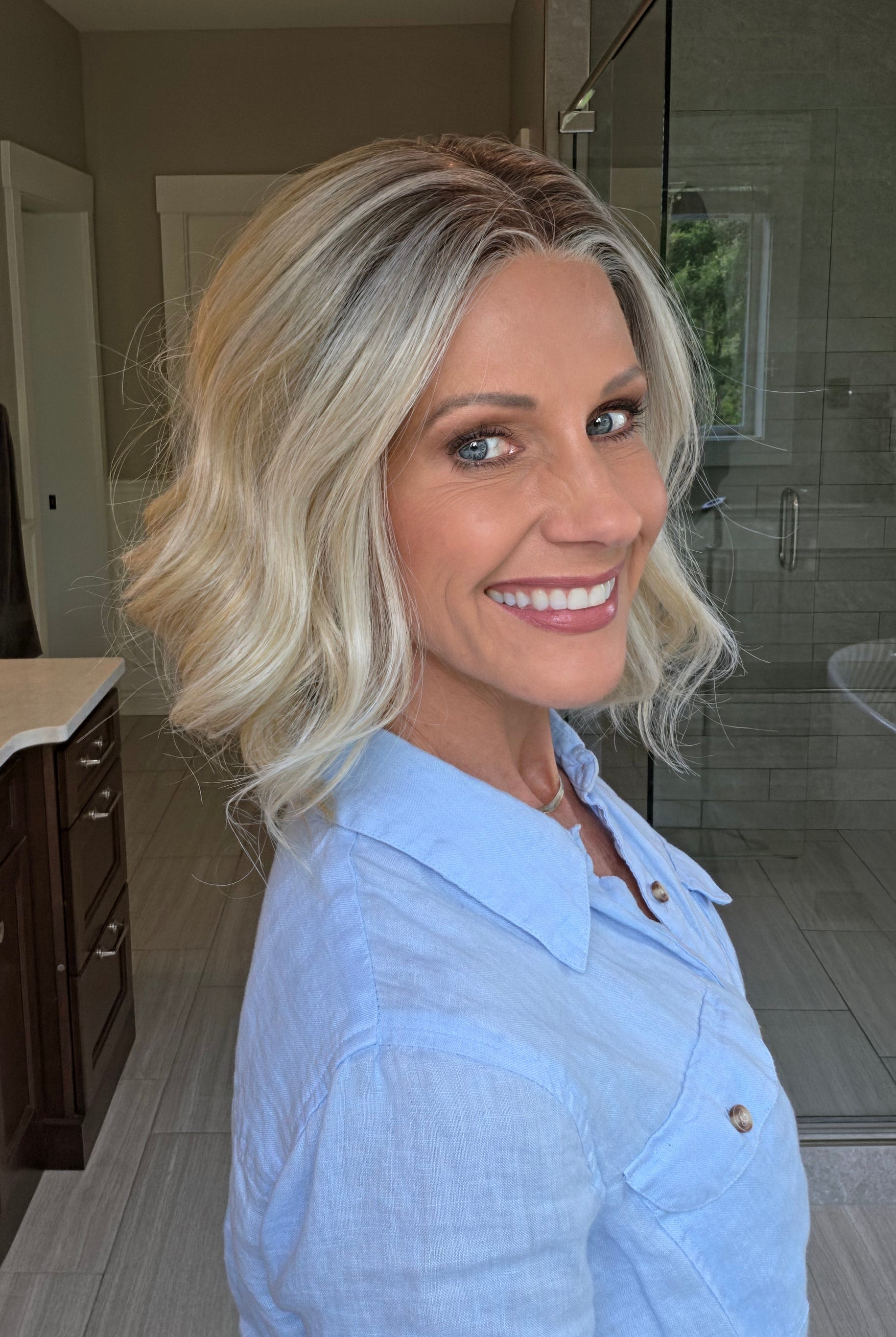 Woman wearing shoulder length curly blonde wig (Brielle by PUSH Hair in color Golden Champagne R)