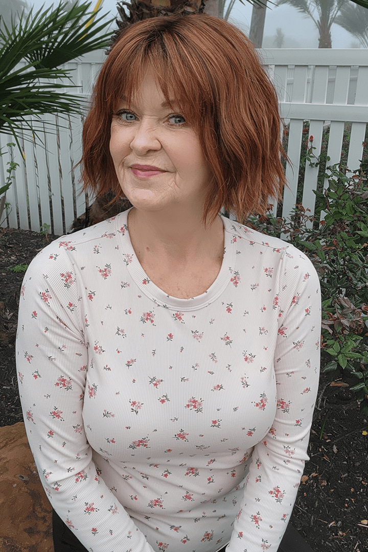 Woman wearing chin length bob with bangs (Rene of Paris' Rosanna in color Autumn Sunrise)