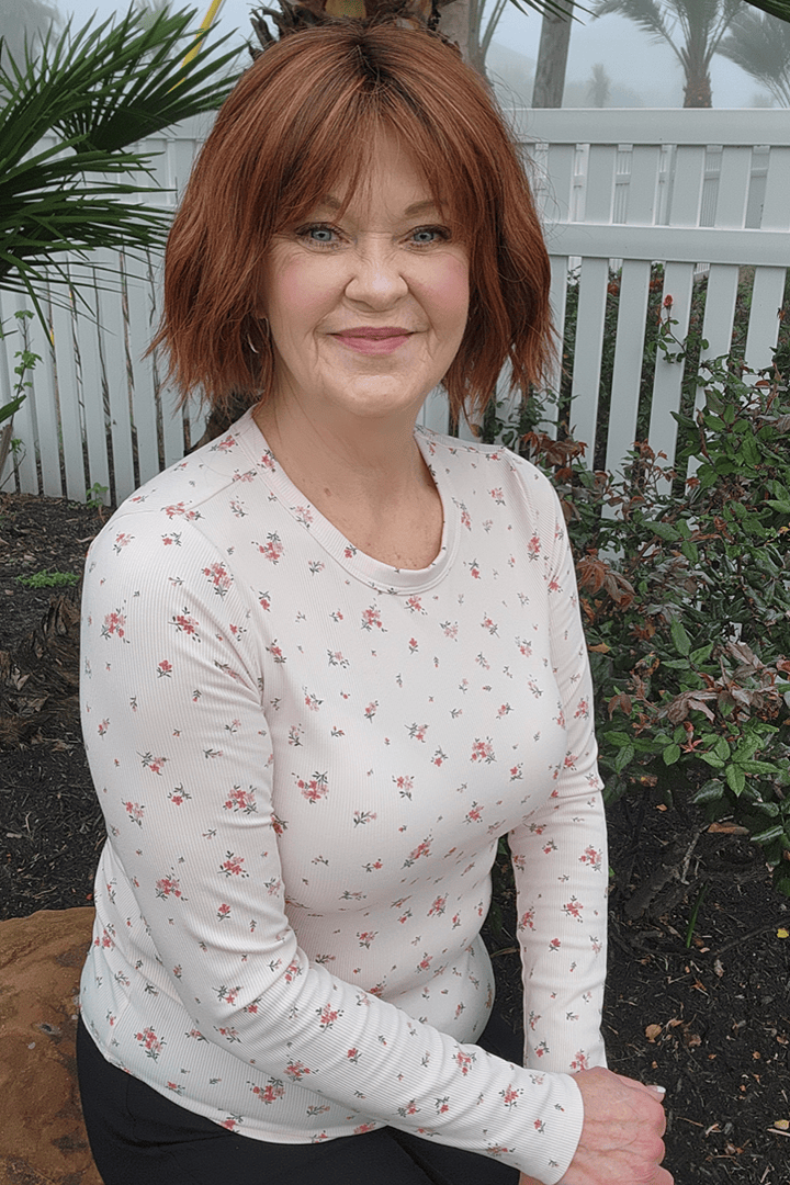 Woman wearing chin length bob with bangs (Rene of Paris' Rosanna in color Autumn Sunrise)