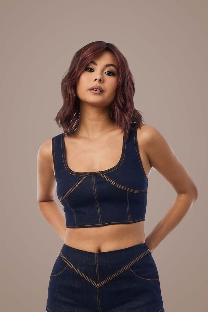 Woman with deep plum hair in denim top