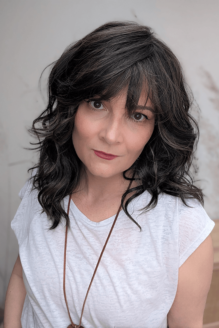 Woman wearing curly shouldar length (Belle Tress' Westwood in Coolest Dark Brown R)