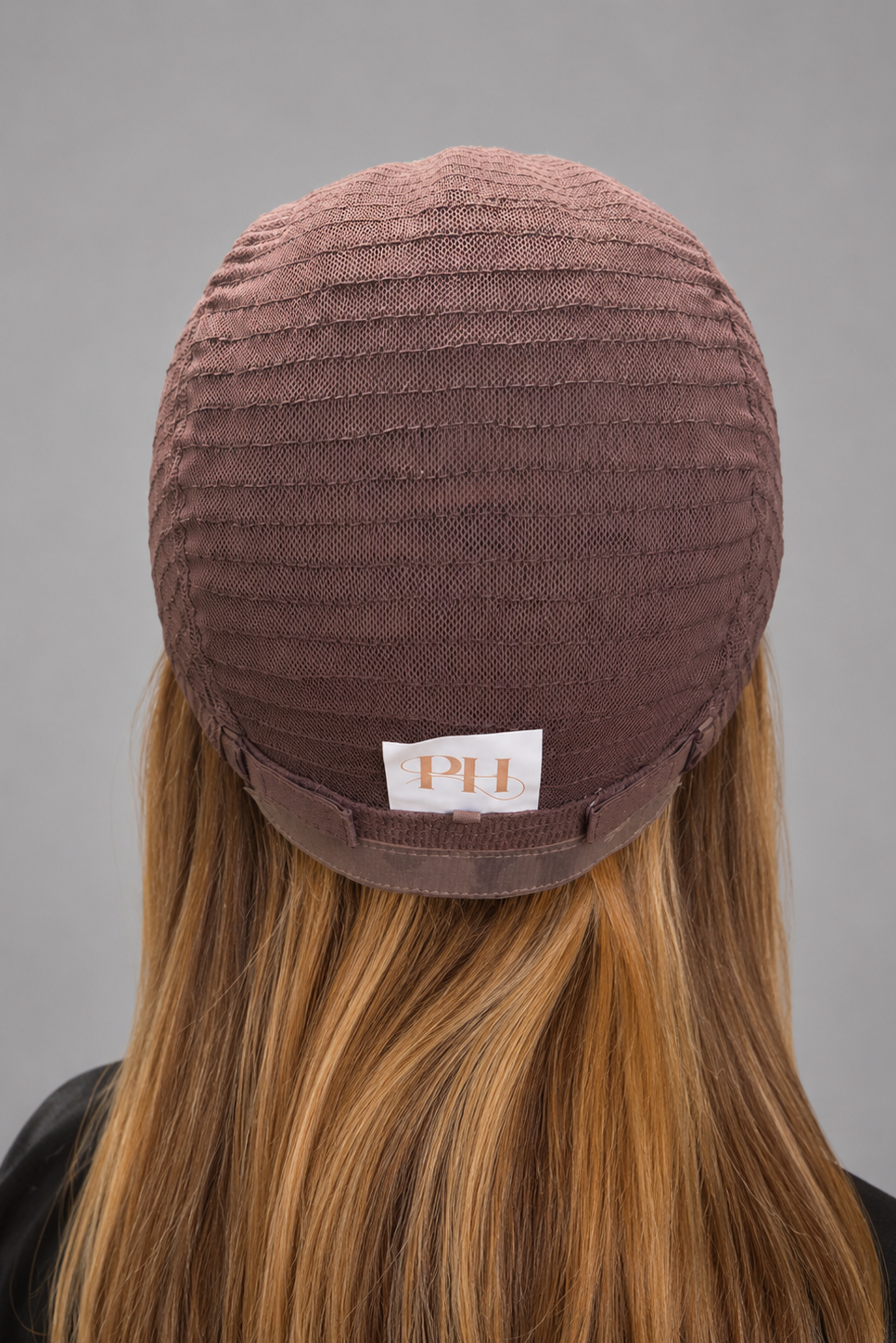 Woman wearing wig turned inside out to show back of wig cap construction.