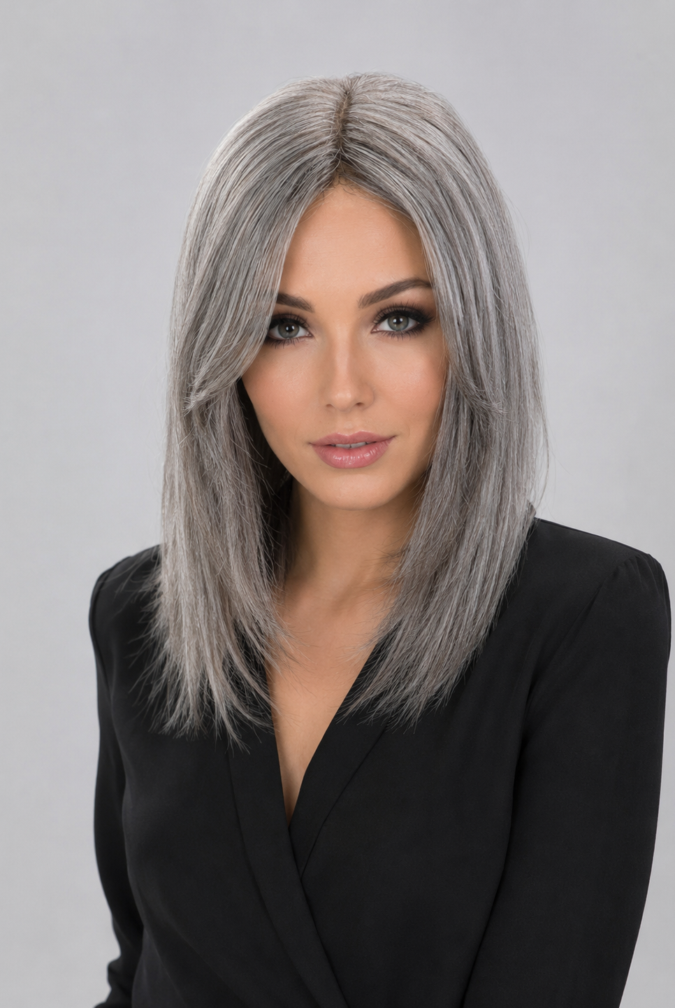 Woman wearing a Bespoke human hair wig by PUSH hair in color Sage, wearing a black blouse against a light grey background - front view