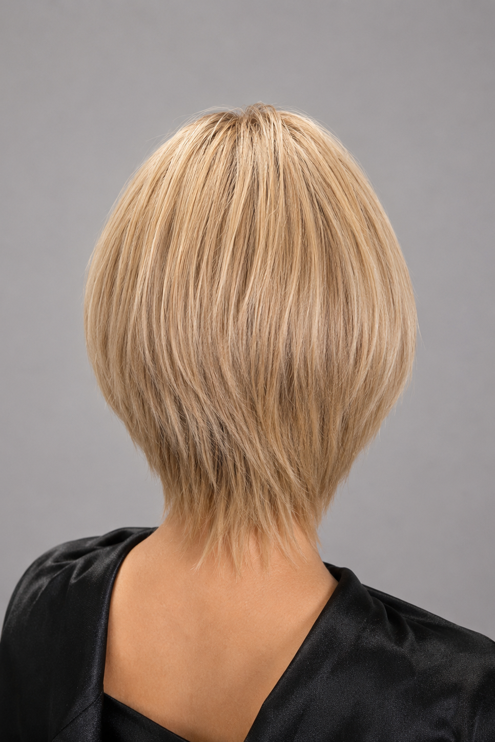 Woman wearing short human hair wig by PUSH in color Champagne Rooted | Back view.