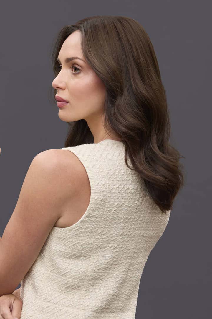 Woman wearing a 14-inch brown Remy human hair topper with a natural, wavy style and light-density coverage.