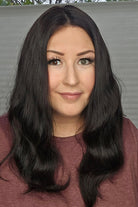 Woman with long black hair wearing a maroon top against a neutral background