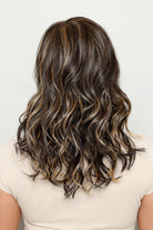 Back view of Sage by Henry Margu, a medium-length synthetic wig with layered, wavy dark brown hair and blonde highlights.