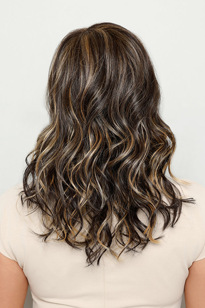 Back view of Sage by Henry Margu, a medium-length synthetic wig with layered, wavy dark brown hair and blonde highlights.