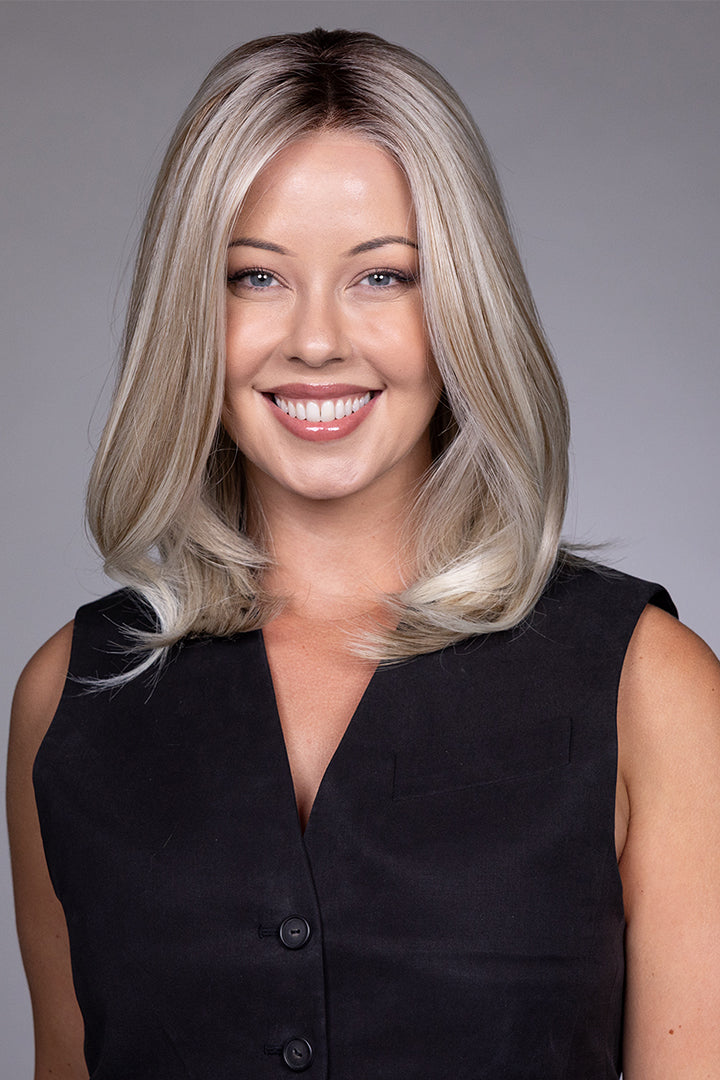 Adriana by Belle Tress layered blonde bob wig with lace front and monofilament top on a smiling model.