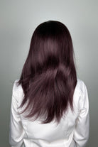 A woman with long, dark purple hair wearing a white button-down shirt (Adeline by PUSH Hair in color Belle Violette).