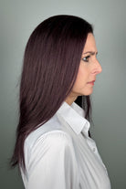A woman with long, dark purple hair wearing a white button-down shirt (Adeline by PUSH Hair in color Belle Violette).