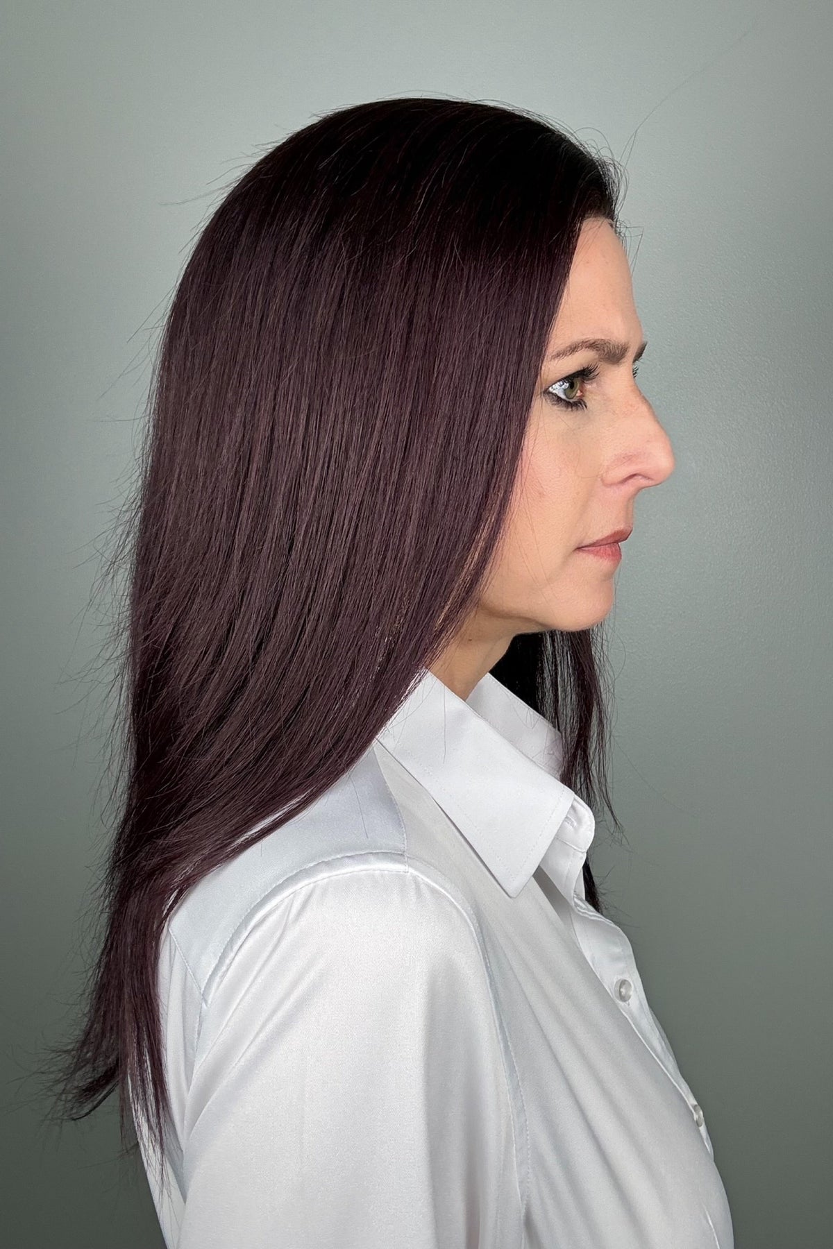 A woman with long, dark purple hair wearing a white button-down shirt (Adeline by PUSH Hair in color Belle Violette).