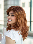 Woman wearing Alana synthetic wig by Envy in color Lighter Red wearing a white blouse in an indoor setting. Left side