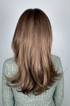 A woman with shoulder-length brown hair and bangs, wearing a textured light gray knit sweater (All Grown Up by Toni Brattin in color Light Brown).